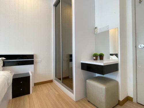 a bedroom with a mirror and a bed and a stool at The Wave Suites Melaka in Melaka