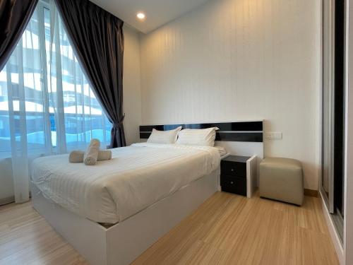 a bedroom with a large bed and a large window at The Wave Suites Melaka in Melaka