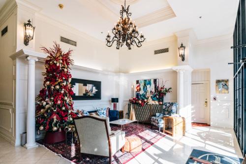 un árbol de Navidad en una sala de estar con una lámpara de araña en Church Street Inn en Natchitoches