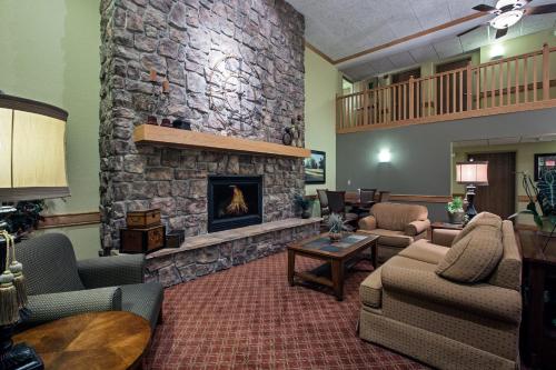 a large living room with a stone fireplace at AmericInn by Wyndham Newton in Newton