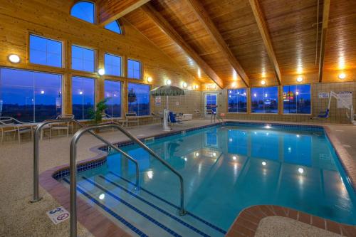 a swimming pool in a building with a wooden ceiling at AmericInn by Wyndham Newton in Newton