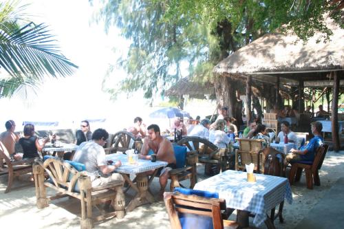 a group of people sitting at tables on the beach at Kirati Beach Resort in Choeng Mon Beach
