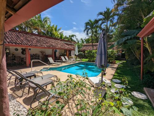 - une piscine avec des chaises et un parasol à côté d'une maison dans l'établissement Villa Botero By Casa Mojito, à Santa Clara
