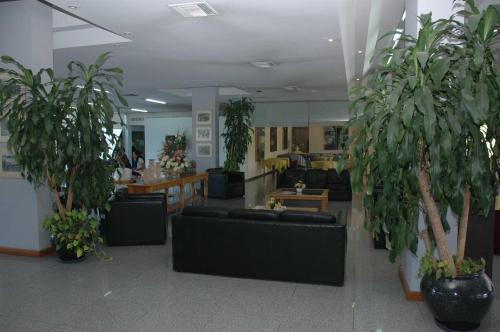
a living room filled with furniture and plants at Hotel Dr. Cesar C. Carman in Córdoba
