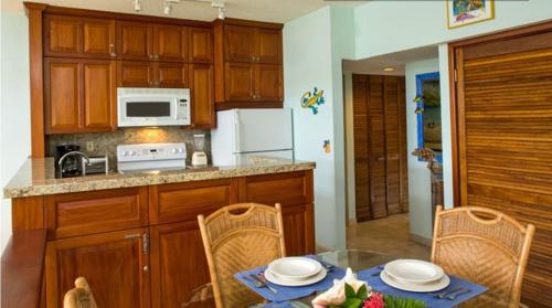 a kitchen with a table with chairs and a microwave at Gallows Point Resort in Saint John