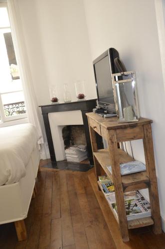 Cette chambre dispose d'une cheminée et d'une télévision sur une table. dans l'établissement La Cour du 5ème - Chambre d'hôtes, à Paris