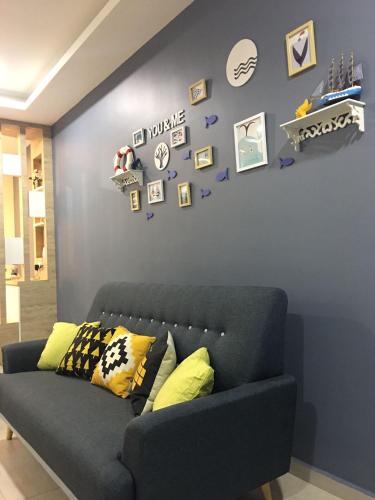 a blue wall with a couch in a living room at ATLANTIS@MELAKA BY SWEETSTAY in Melaka