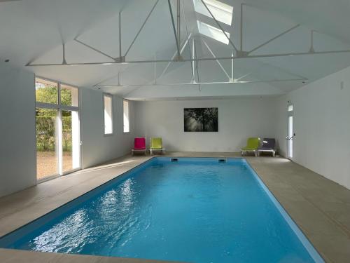 una gran piscina de agua azul en una habitación en Domaine de Bel Air en Cérans-Foulletourte