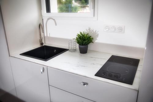 - une cuisine blanche avec évier dans l'établissement L'à Côté, à Colmar