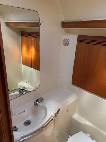 y baño con lavabo y espejo. en SUPERBE VOILIER CAP AGDE avec parking gratuit sur place, en Cap d'Agde
