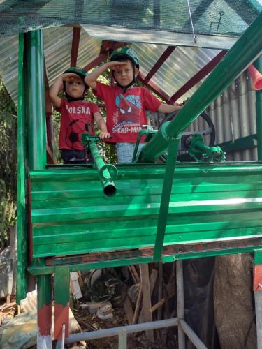 two children are sitting in a green train at VILLA GUT in Bolesławiec