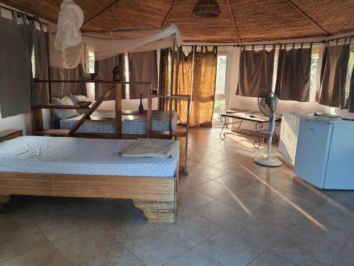 a bedroom with two bunk beds and a refrigerator at la villa sur la plage in Palmarin