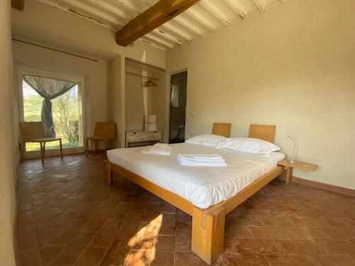 um quarto com uma grande cama branca num quarto em Agriturismo Pian Di Meta Vecchia em Castiglione dʼOrcia