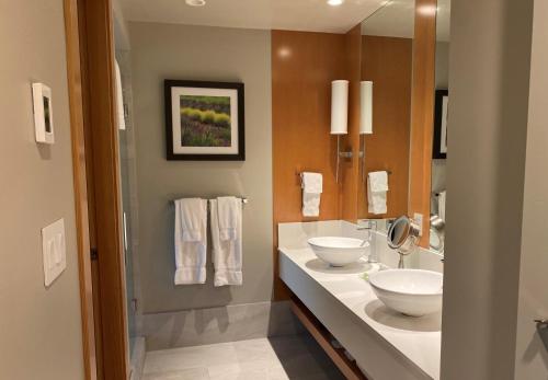 a bathroom with two sinks and a mirror at Penticton Lakeside Resort in Penticton