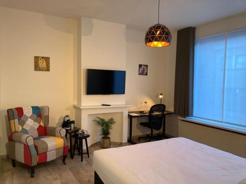 a bedroom with a bed and a tv and a chair at RS10 Turnhout in Turnhout