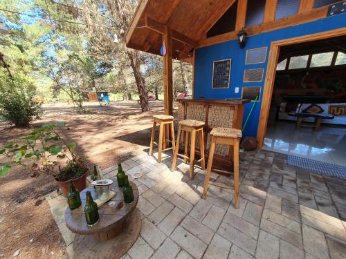 a patio with a bar and stools in front of a house at Cabañitas del Bosque in Algarrobo