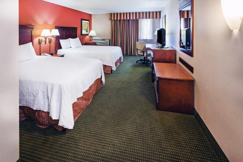 a hotel room with two beds and a television at AmericInn by Wyndham Omaha in Omaha