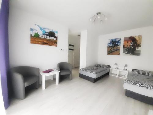 a room with two beds and a table and chairs at Apartament Złota Łącza in Zielona Góra