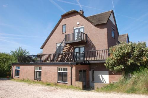 una grande casa in mattoni con balcone di villa Flore, studio's a Bergen aan Zee