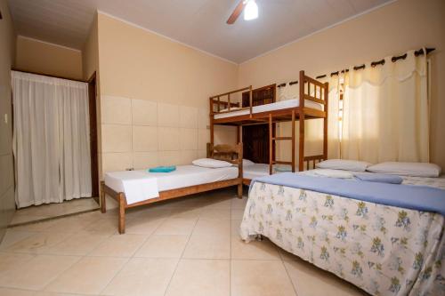 a room with two beds and a bunk bed at Pousada Quatro Estações Paraty in Sertão do Taquari
