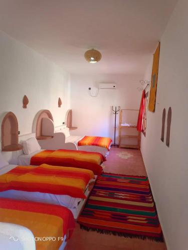 a row of beds sitting in a room at Hôtel Restaurant La Gazelle De Dades in Akhendachou nʼAït Ouffi