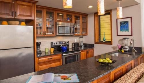 a kitchen with a stainless steel refrigerator and wooden cabinets at Gallows Point Resort in Saint John