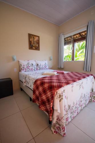 a bedroom with a bed with a plaid blanket at Pousada Quatro Estações Paraty in Sertão do Taquari