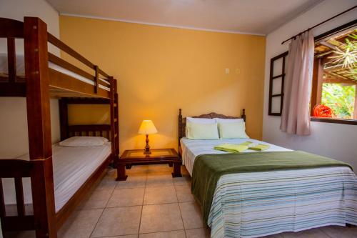 a bedroom with two bunk beds and a lamp at Pousada Quatro Estações Paraty in Sertão do Taquari