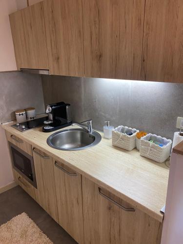 a kitchen counter with a sink and some baskets at Apartman Sky View, Župa Wellness & Spa u Centru Kopaonika in Kopaonik