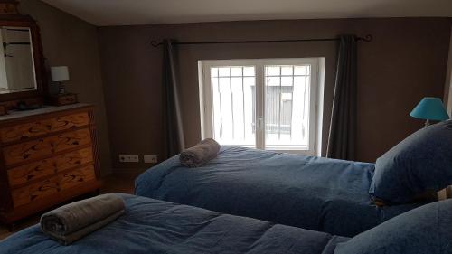 a bedroom with two beds next to a window at Callian: lumineux duplex avec terrasse et vue in Callian