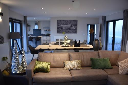 a living room with a couch and a dining room table at Rochehaut, Les Semoiselles, Villa Isabelle in Bouillon