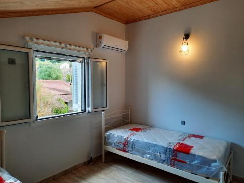 a small bedroom with a bed and a window at NICK & JERRY in Kefallonia