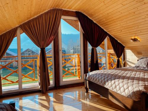 a bedroom with a bed and large windows at Eco Centr Zrub in Maydan