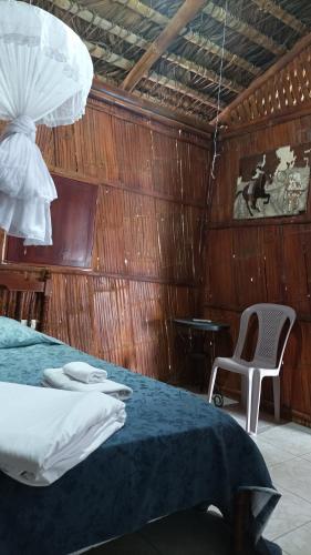 a bedroom with a bed and a chair and a table at Hostal Villa Brisa in Ballenita