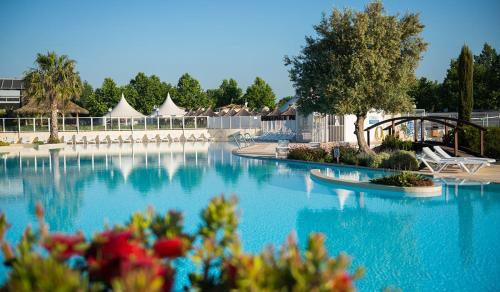 - une grande piscine avec des chaises, des arbres et des tentes dans l'établissement VIAS PLAGE - PISCINE LAGON ! MER A 500 M ! Camping 4 ETOILES MHome T confort 3 Ch, à Vias
