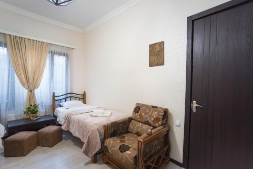 a bedroom with a bed and a chair and a bed at Terrace House Near Opera in Tbilisi City