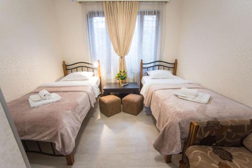 two twin beds in a room with a window at Terrace House Near Opera in Tbilisi City