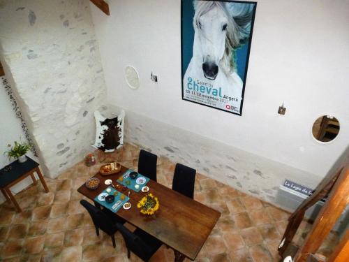 a table with a picture of a horse on the wall at Le Logis de la Chouette in Baugé-en-Anjou