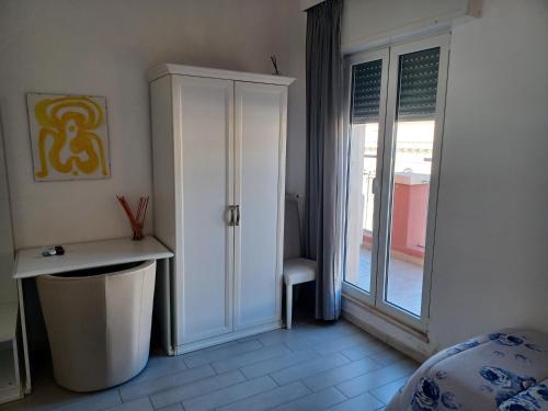 a bedroom with a white cabinet and a window at Hotel Costa in Bari