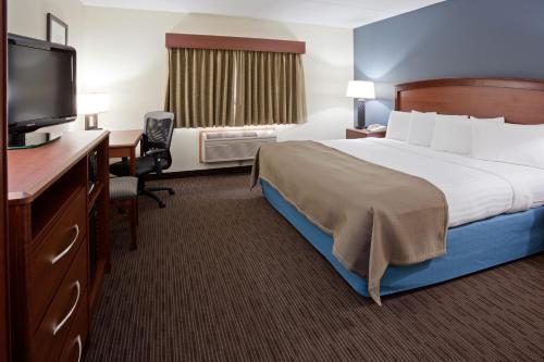 a hotel room with a bed and a desk and a television at AmericInn by Wyndham Princeton MN in Princeton