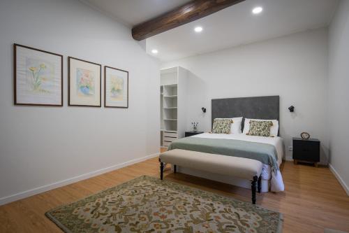 ein weißes Schlafzimmer mit einem Bett und einem Teppich in der Unterkunft Casa de Santa Rita in São Roque