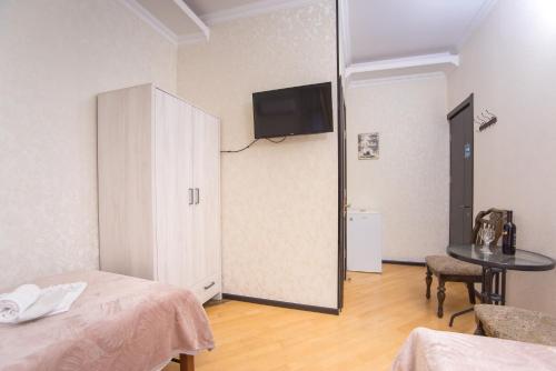 a room with a bed and a cabinet and a table at Terrace House Near Opera in Tbilisi City