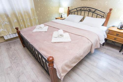 a bedroom with a large bed with two towels on it at Terrace House Near Opera in Tbilisi City