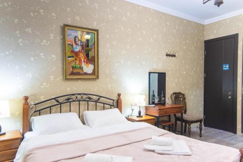 a bedroom with a bed and a table and a desk at Terrace House Near Opera in Tbilisi City