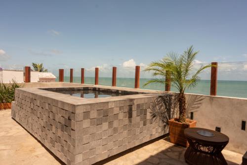 a swimming pool in a brick wall with a palm tree at Maré Loft Praia in Icaraí