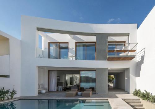 a white house with a swimming pool in front of it at Villa Mimaze Minimalist Living in Elounda