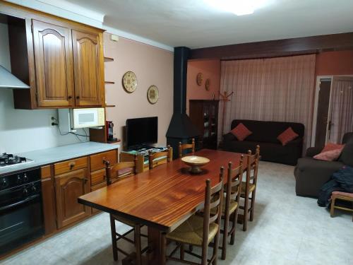 cocina y sala de estar con mesa de madera y sillas en Casa cèntrica a La Bisbal d'Empordà en La Bisbal