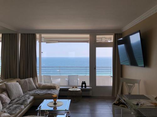 a living room with a couch and a view of the ocean at Tiffanys Ferienapartments in der Privatresidenz des Plaza Premium Hotel Timmendorfer Strand in Timmendorfer Strand