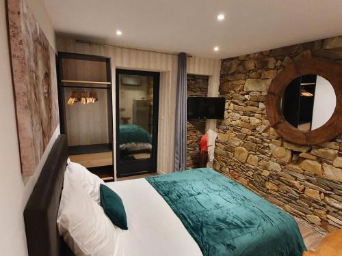 a bedroom with a large bed in a stone wall at Appartements C'Home un charme in Lannion