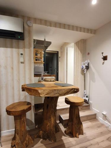 een keuken met een grote houten tafel en 2 krukken bij Appartements C'Home un charme in Lannion